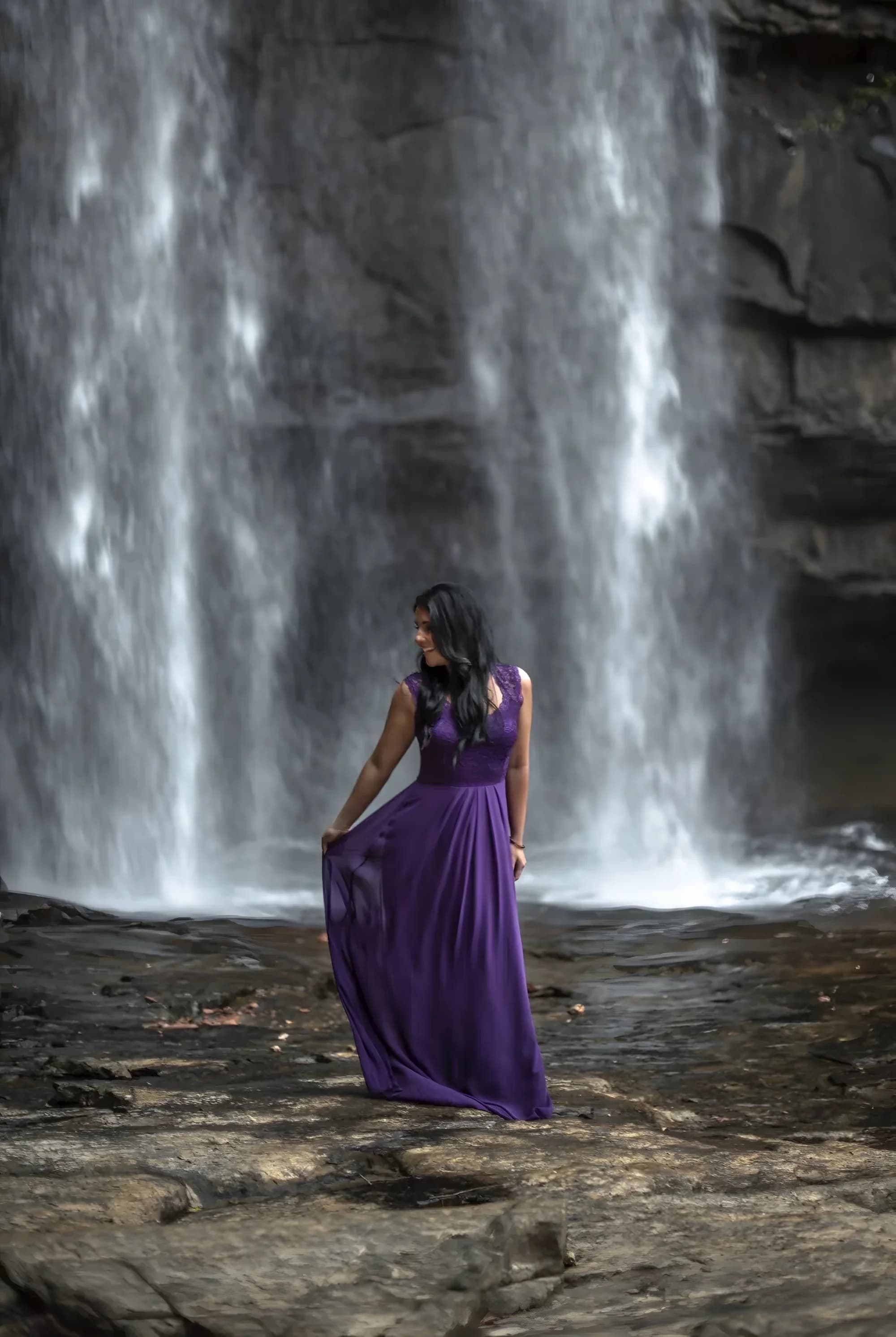 Danielle at a waterfall in a purple gown